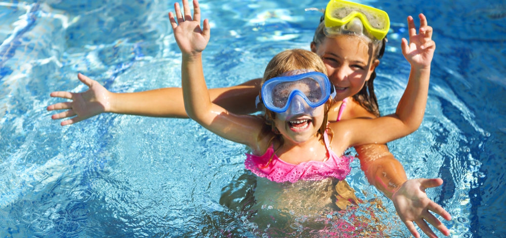 Two funny girls playing in swimming pool. Vacation and travel concept